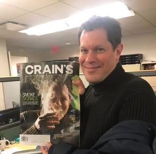 Doug Greene poses with the Crain's magazine cover on which he was featured. (Facebook)