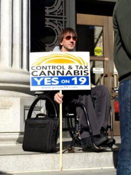 man in wheelchair holding sign